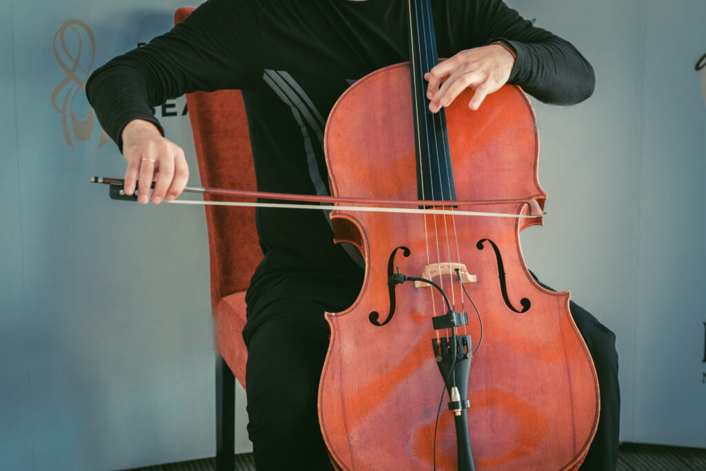 Man sitting on chair and plating cello