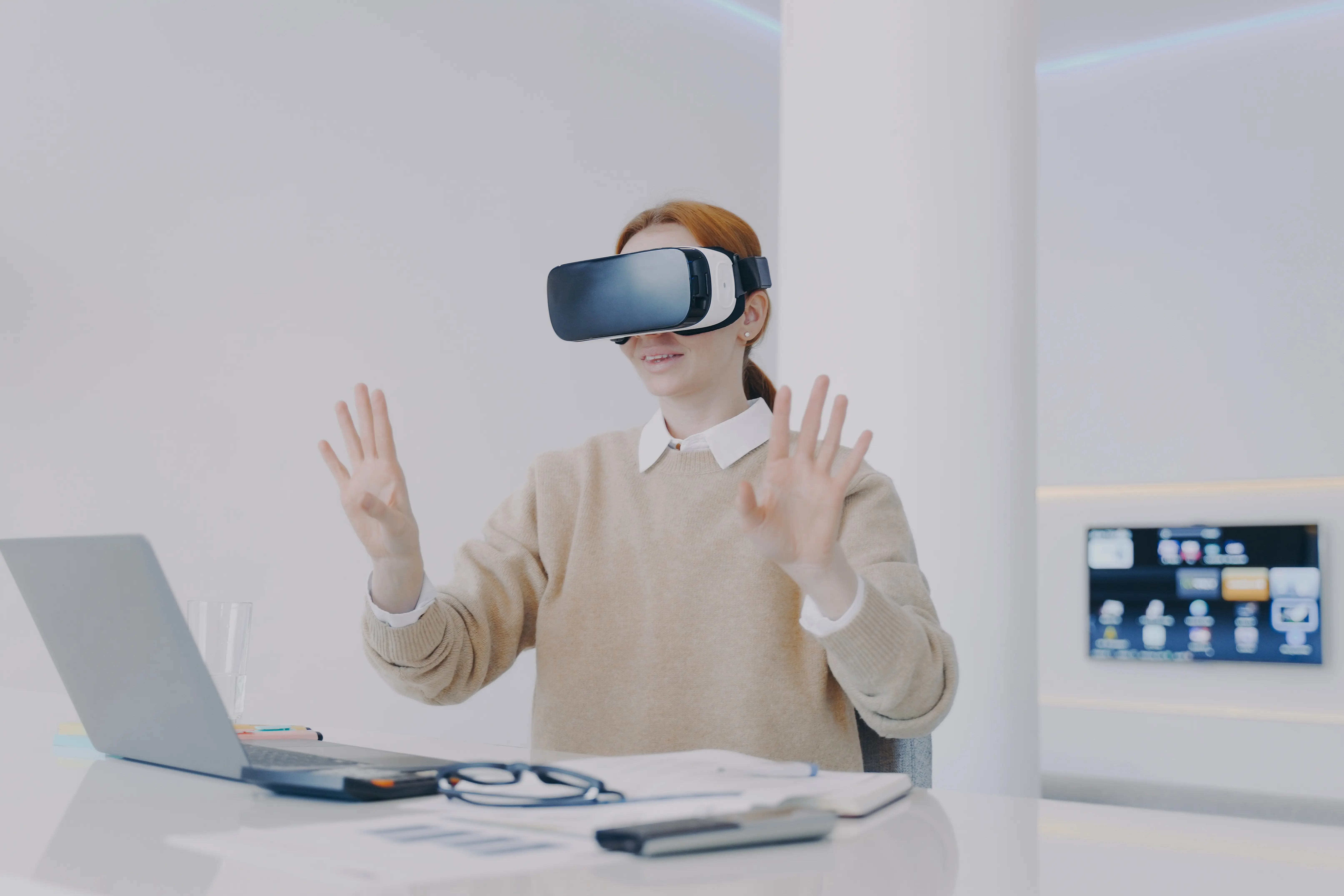 Young contemporary european woman in VR headset is working in office. Future innovations concept.