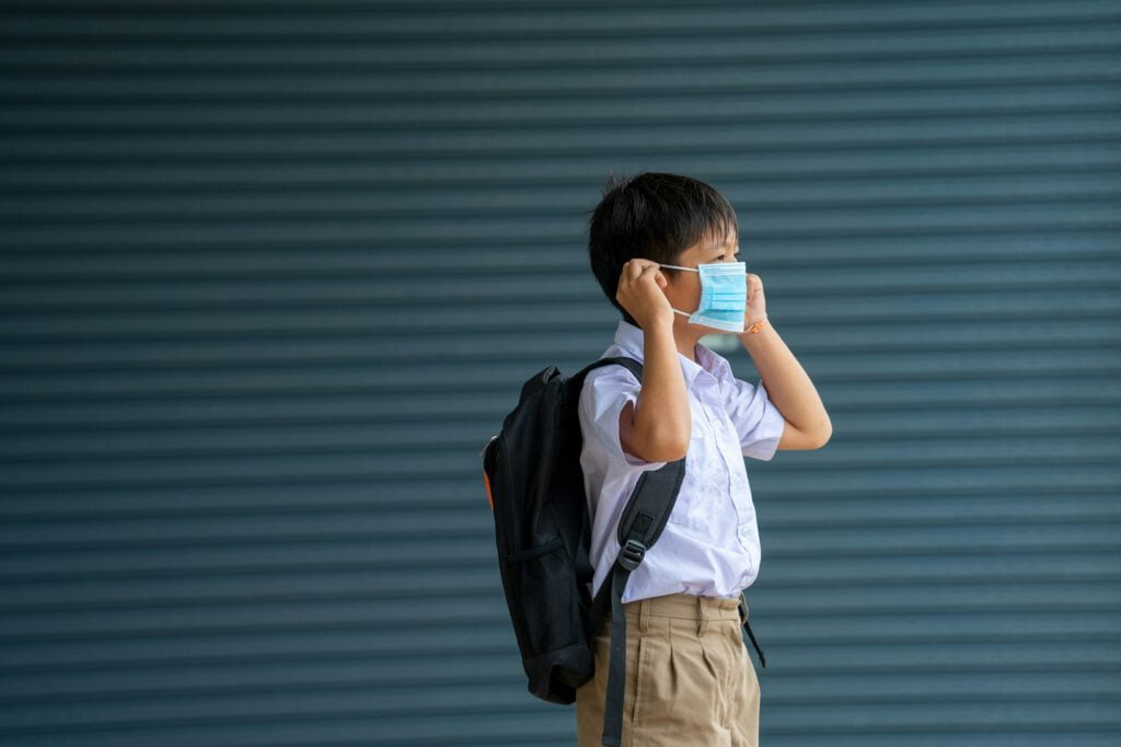 Elementary school students with face mask back at school after covid-19 quarantine and lockdown.