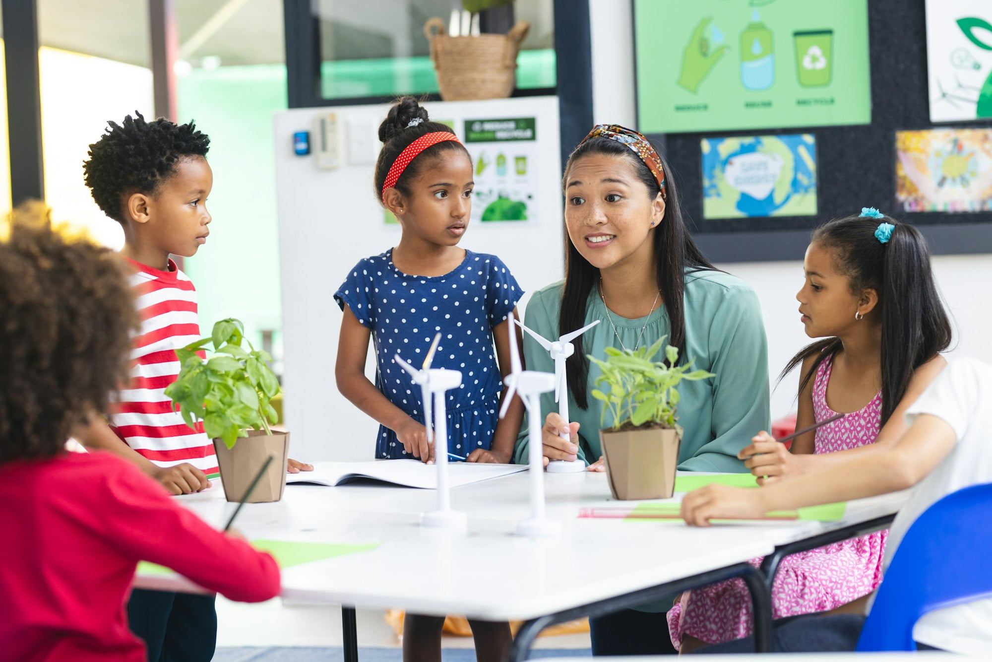In school, diverse group of students and their teacher discuss sustainability in the classroom