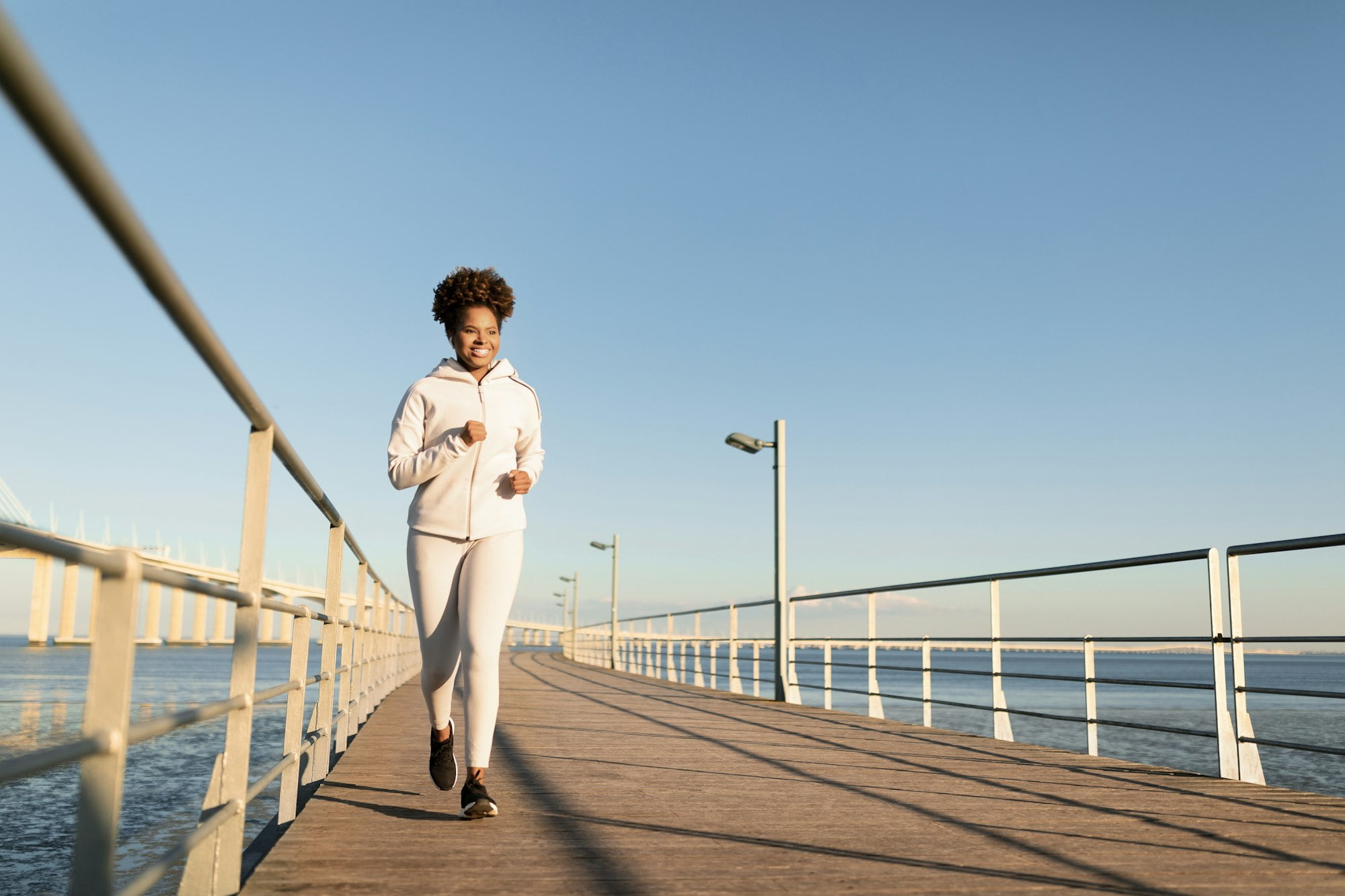 Outdoor Sports. Young Black Woman Jogging Outside On Wooden Pier Near Sea